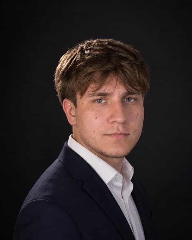 Bruno Jaamaa in a navy blazer and white shirt against a dark background